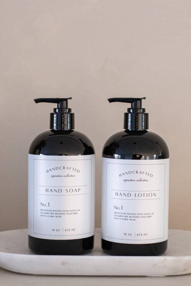 Two elegant black pump bottles displayed on a marble surface.
